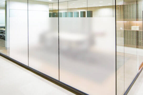 Vue extérieure d’une salle de réunion avec des vitres recouvertes de films dépolis pour assurer la confidentialité.